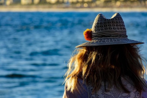 Woman with flower hat looking at Ipanema beach and city during afternoon