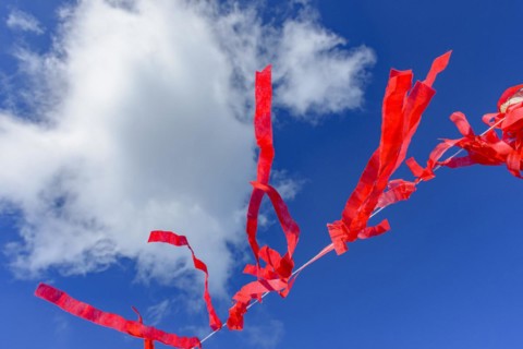 Decorative vivid red ribbons prepared for a religious festival in the city of Lavras Novas in Minas Gerais swaying in the wind with blue sky