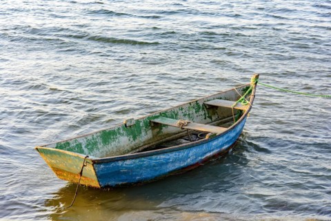 Old wooden fishing boat floating over sea