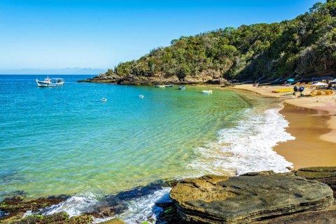 Paradise beach with colorful transparent waters surrounded by stones and vegetation in the city of Buzios