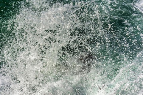 Texture of drops of sea water splashing into the air when waves crash against rocks