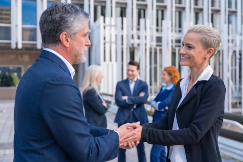 Successful Executives Congratulating Each Other in a Commercial Hub
