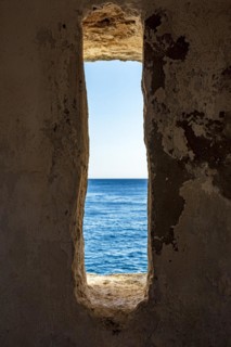 A window to the sea. View of the sea and horizon in the guardhouse of an old fortress from the 17th century in the city of Salvador