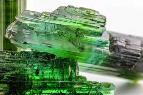 Three brazilian green tourmaline raw crystal with white background