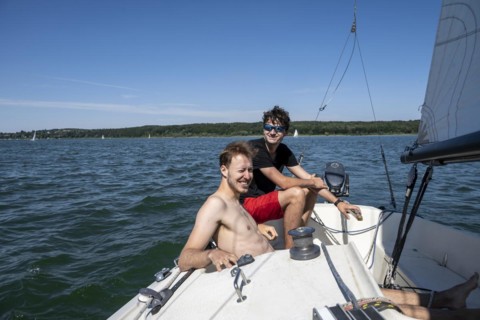 Two young men sailing on a sailboat
