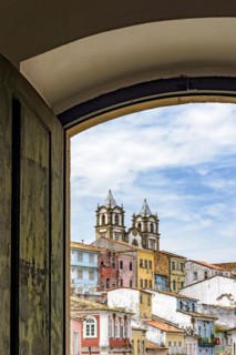 View of the famous Pelourinho neighborhood in the city of Salvador through an old colonial style wooden window