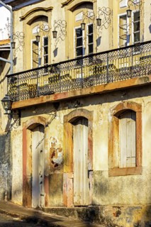 Facade of old house in colonial architecture worn by time in the city of Ouro Preto
