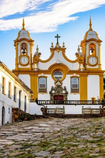 Facade of a historic church in baroque style built in the 18th century cobblestone street with houses in the city of Tiradentes in Minas Gerais