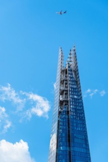 Airplane over a glass skyscraper