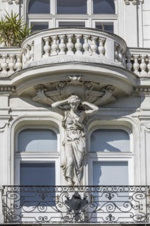Baroque statue as support of a balcony on the left Wienzeile