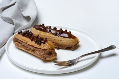 Two chocolate eclairs on a plate