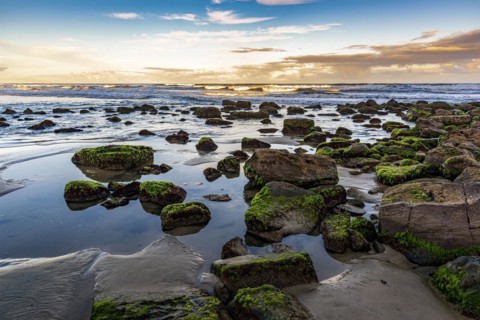 Quiet and deserted beach with rocks during sunset in the city of Torres in Rio Grande do Sul