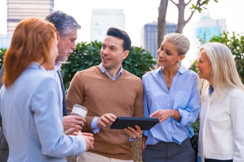 Cheerful Portrait of a happy group of co-workers laughing and having fun outdoors a corporate office area. High quality photo
