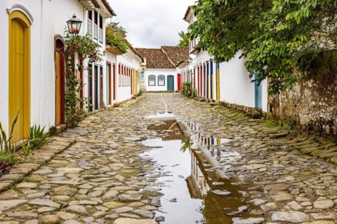Cobblestone street with colorful colonial houses and reflections in the puddles in the historic city of Paraty