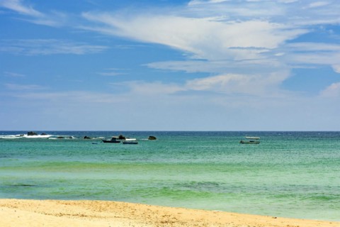 Wooden fishing boats on the colorful waters of Itapua beach in Salvador