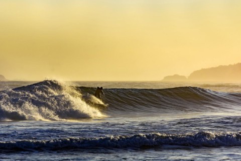 Silhouette of surfer on Ipanema beach during summer sunset