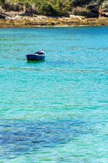 Old wooden fishing boat floating on the colorful and transparent waters of the sea of Buzios in the state of Rio de Janeiro