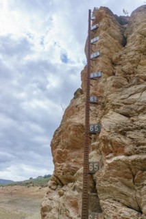 Metal water level gauge in a reservoir emptied by drought and climate change