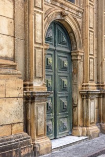 Large green wooden door and stone facade at the entrance to the old historic church in Pelourinho in Salvador