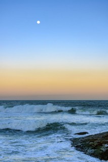 Moon over the sea and waves during sunset at Ipanema beach in Rio de Janeiro