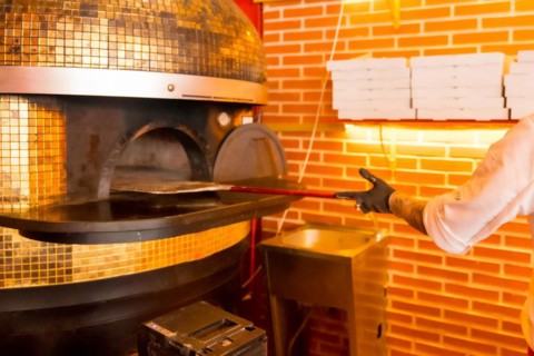 Artisan pizza oven. Chef introducing with the shovel