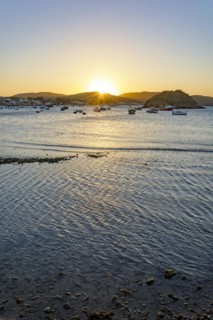 Sunset behind the hills and reflected in the sea waters of the city of Buzios on the north coast of Rio de Janeiro