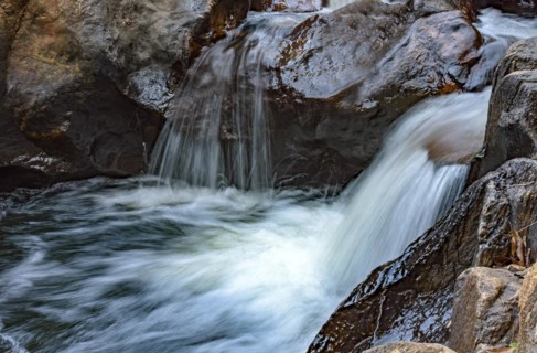 Small creek with clear waters and casacade running through the rocks of the mountains of Minas Gerais