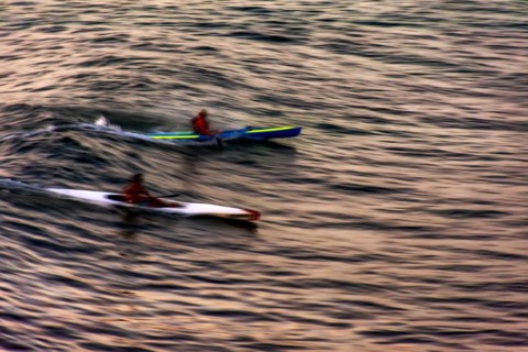 Canoeing at sunset in the sea of the city of Salvador in Bahia with blurred motion and unrecognizable people