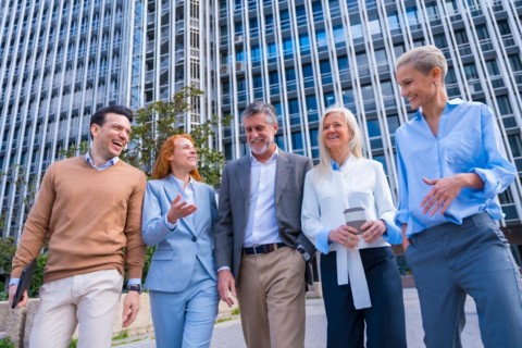 Group of coworkers walking going to work outdoors in a corporate office area