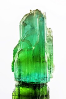 Brazilian crude green tourmaline crystal with white background