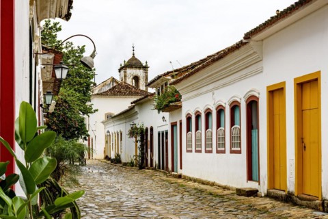 Cobblestone street in the historic center of Paraty with old church in the background