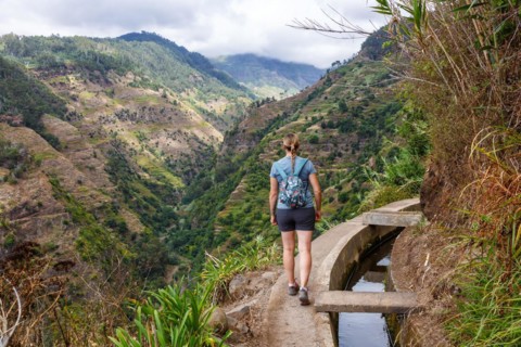 Young woman hiking along the Levada Nova hiking trail on Madeira Island