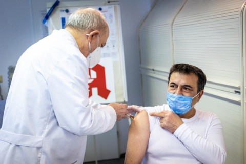 A pharmacist vaccinates a man with the Comirnaty BioNTech vaccine against the coronavirus in a pharmacy in Duesseldorf