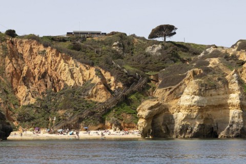 Wooden steps leading to the sandy beach of Praia do Camilo on the rocky coast of Lagos