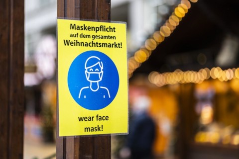 A sign indicating that masks are compulsory stands out at the Christmas market on Alexanderplatz in Berlin