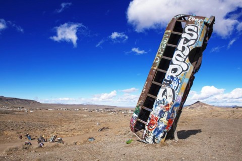 School bus sunk into the ground and sprayed with graffiti