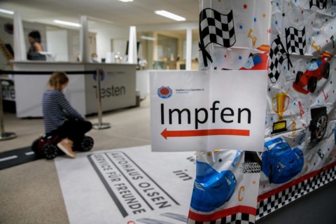 A sign points the way to vaccination at a COVID-19 vaccination and testing centre at Autohaus Olsen in Iserlohn