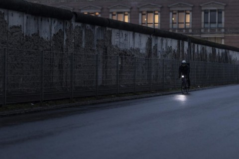 A cyclist stands out in front of the Berlin Wall in Berlin