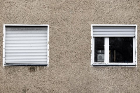 Lowered blinds stand out at an abandoned residential building in Berlin
