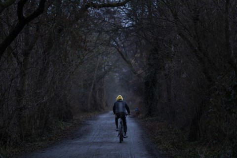 A man rides his bicycle along the Teltow Canal in Berlin