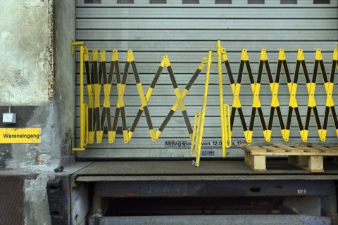 Barrier fence in front of a rolling gate in a former paper factory