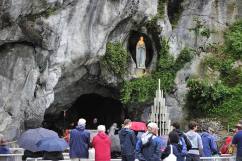 Pilgrims praying in front of the grotto at the Sanctuary of Our Lady of Lourdes