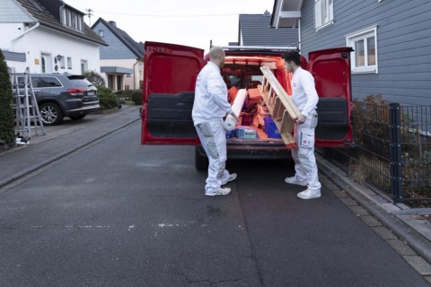 Subject: Master painter and apprentice loading a van with work materials