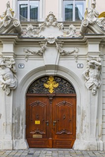 Round arched front door framed with stone figures