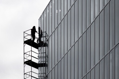 A construction worker is silhouetted on scaffolding in Berlin