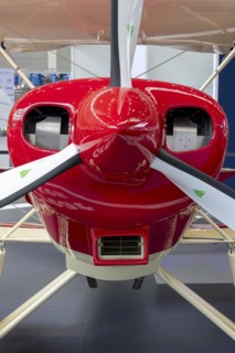 The front part of the aircraft with the propeller with red engine cowling and engine cooling vents