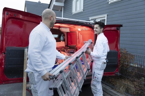Subject: Master painter and apprentice loading a van with work materials