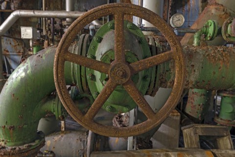 Rusty shut-off wheel on a water pipe of a former paper factory