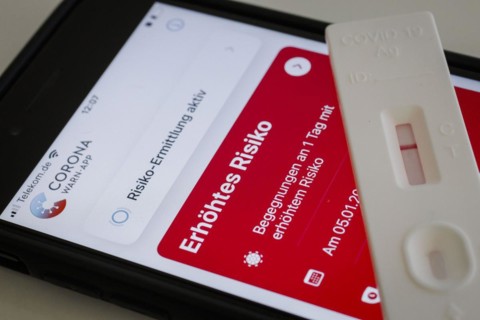 A negative rapid test is on a smartphone on which the Corona Warn app displays the words Increased Risk. Berlin