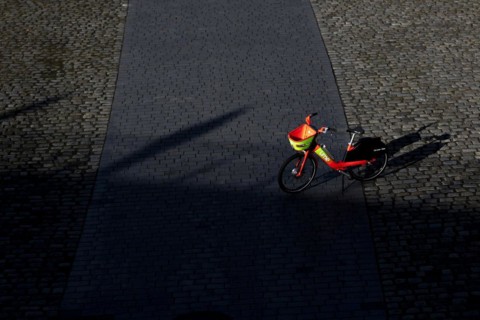 A rental bike from Lime stands on crosswise on the footpath in Berlin